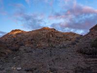 Abendlicht auf den Bergspitzen im Barranco del Cura mit farbigen Wolken
